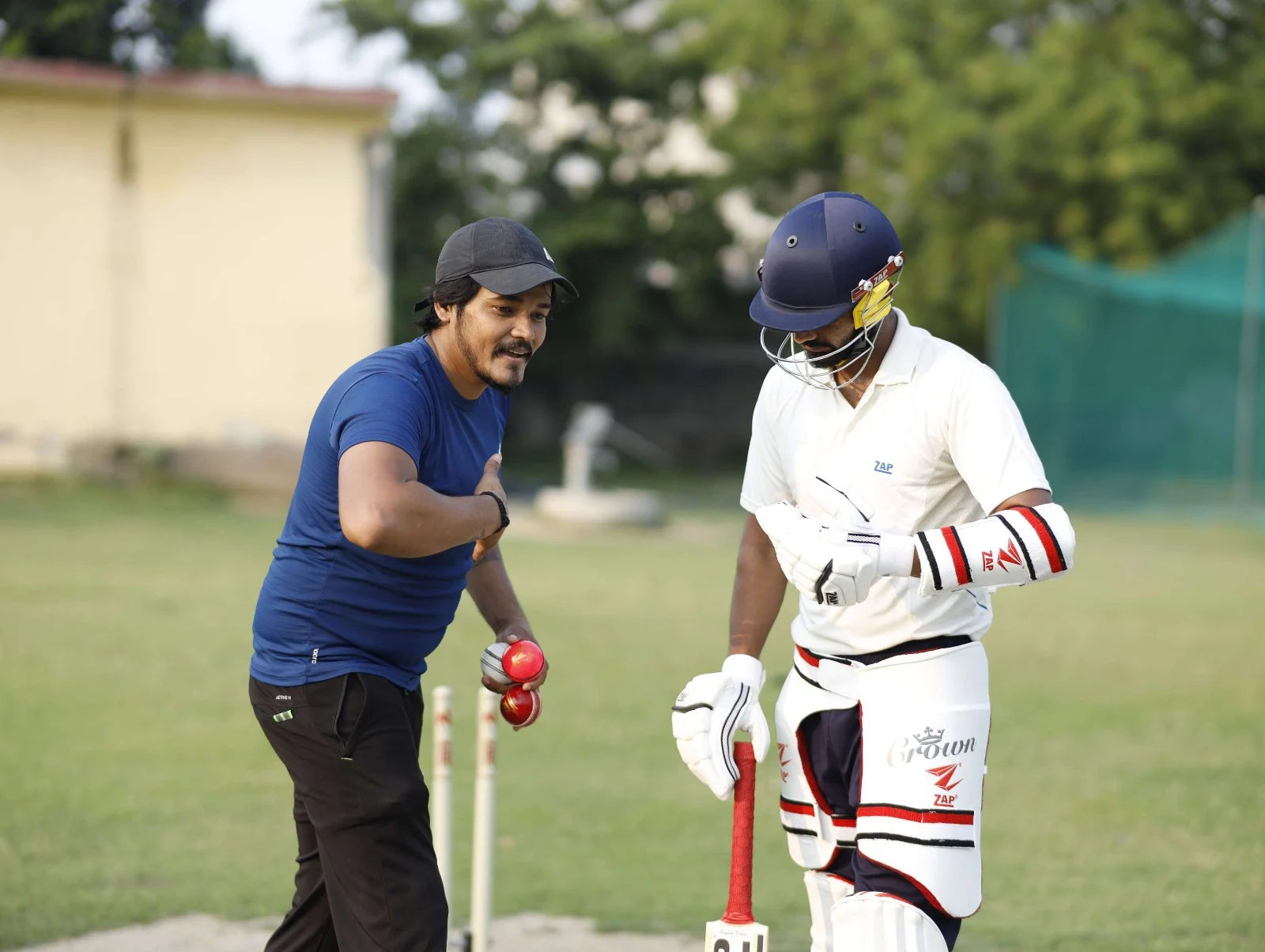 A cricket coach explains the right batting to the batsman