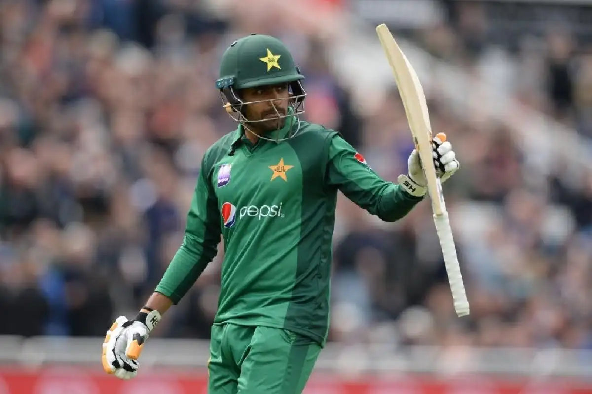 Babar Azam raises his bat to celebrate a century