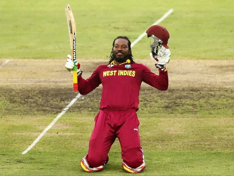 Chris Gayle kneels down and raises his bat to celebrate his double century scoring 215 in the World Cup against Zimbabwe