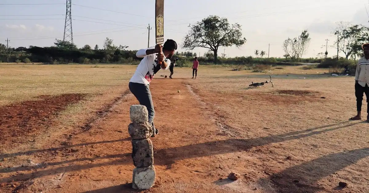People playing tennis ball street cricket in India